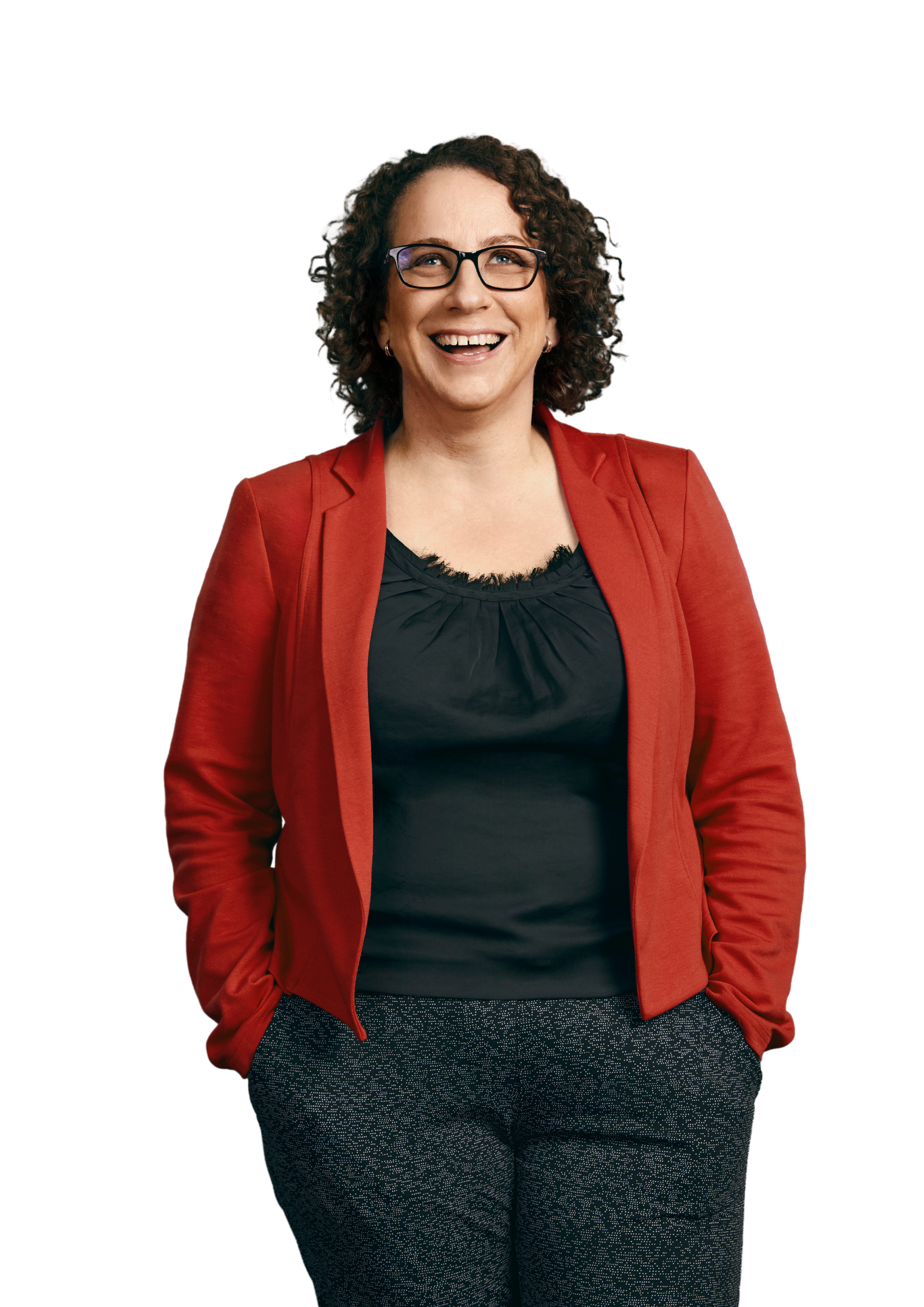 Client Sally is standing with her hands in her pockets and smiling at the camera